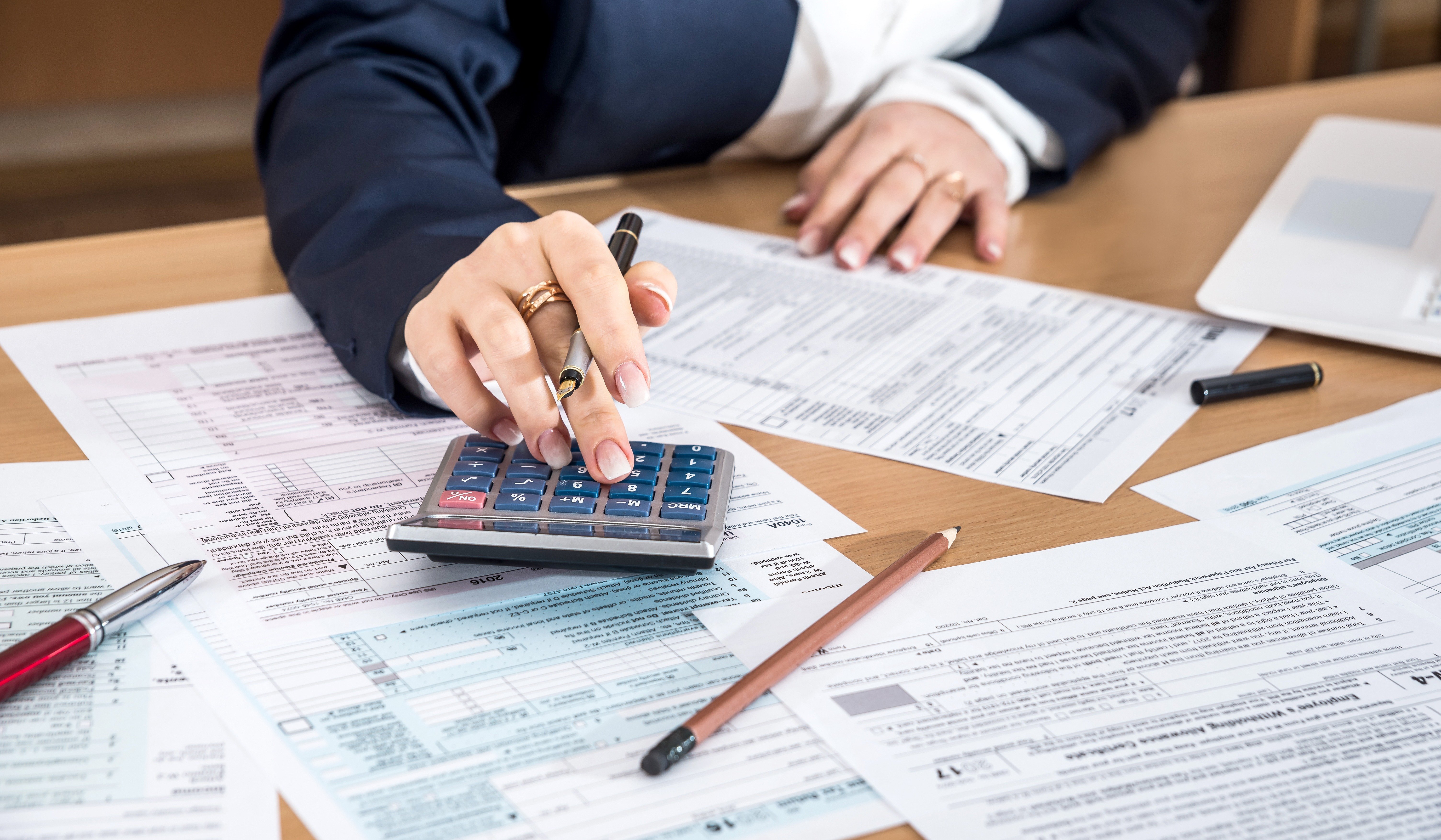 Tax documents and a calculator on a desk with no cash present